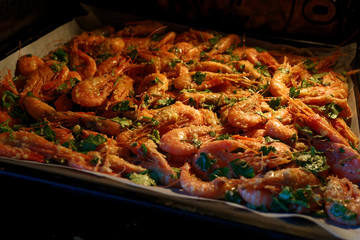 The boiled prawns are spread out on a platter and ready to be baked in the oven. Marinade for seafood