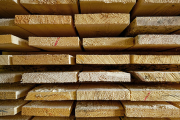 Construction lumber. Dry boards are stacked. A close-up of wood in the end. The background for the woodworking industry and sawmills.