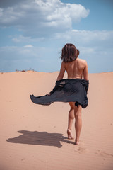 Beautiful girl in black swimsuit in the desert