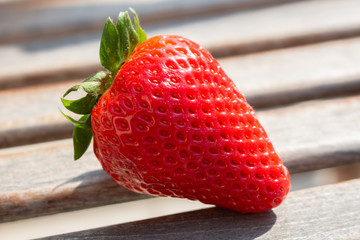Strawberry. Fresh organic berries macro. Fruit background. Full frame. One berry, horizontal orientation. Shallow focus.