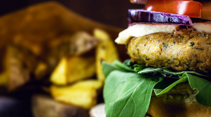 vegan burger on rustic wooden table, with vegetable burger and meat flavor. Healthy vegan food.