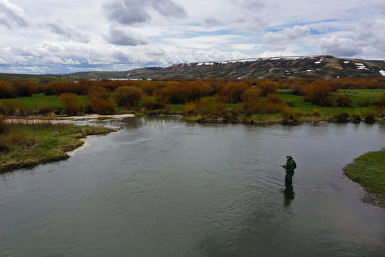 a high resolution aerial shot of a man fly fishing
