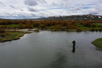 a high resolution aerial shot of a man fly fishing