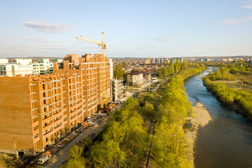 Aerial view of tall residential apartment buildings under construction and Bystrytsia river in Ivano-Frankivsk city, Ukraine.