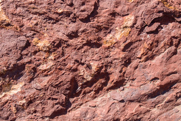 A rocky surface with gold streaks and interspersed. Color - Oriental Pink, Golden Bell. Concept of geology, minerals.