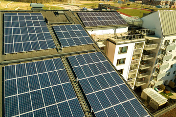 Aerial view of solar photovoltaic panels on a roof top of residential building block for producing clean electric energy. Autonomous housing concept.
