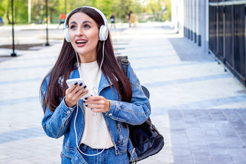 Young woman with phone and headphones outdoor