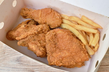 fried chicken and French fries in paper box packing on table