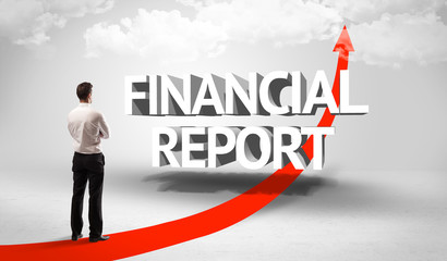 Rear view of a businessman standing in front of FINANCIAL REPORT inscription, successful business concept