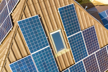 Obraz premium Aerial top view of new modern residential house cottage with blue shiny solar photo voltaic panels system on roof. Renewable ecological green energy production concept.
