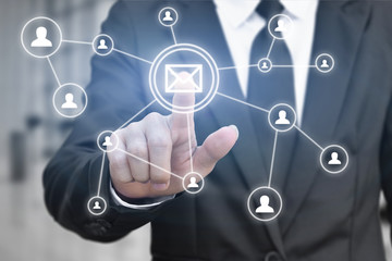 Businessman hand press email button icon on virtual screen for network connection. Idea for contact communication in business.
