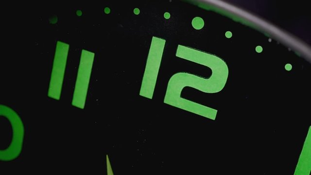 close up on twelve o'clock on the wall clock while the hands turning