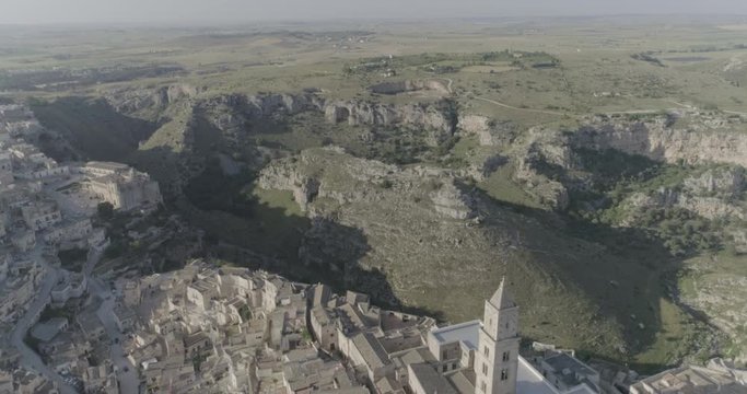 Bari Italy aerial shot. Departure from the mountains to the city. Old town, houses, neighborhoods, roads, canyon, mountains, rocks, trees, lines of houses, architecture, landscape, beautiful drone fli