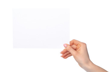 Woman's hand holding blank white sheet of paper isolated on white