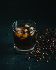 Cold Brew Coffee in Whiskey glass on a countertop with coffee beans
