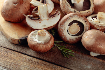Fresh brown mushrooms champignon on a old wooden table.