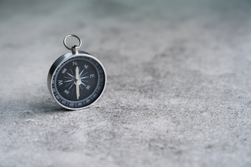 Old compass on stone floor background