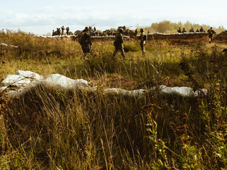 Tanks at firing positions. A group of soldiers on a field position.