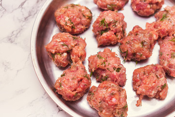 Prepared raw lumps of minced meat on a metal tray