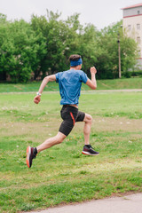 A young athlete in a blue T-shirt runs around the stadium