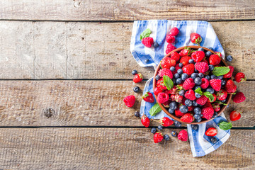 Raw Organic Assorted Various Fresh Berries with Blueberries Raspberries and Strawberries on rustic wooden background