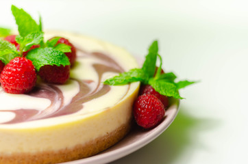 Creamy vanilla baked cheesecake, swirled with raspberry sauce on a biscuit crumb base