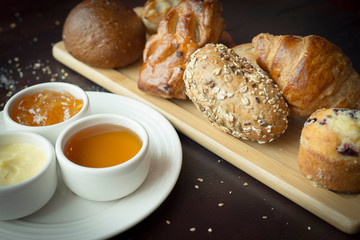 Continental Breakfast, backery, honey and butter, pastry, close up. Traditional continental breakfast, with toast, croissants, muffins, coffee, orange juice and jam.

