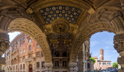 Obraz premium Panoramic composite of arch gallery ceiling, with stone carvings and painted patterns in Quartiere Coppedè, a 20th century Liberty Style architecture district in Rome, Italy