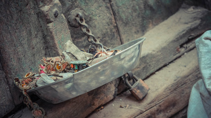 Pile Of Ornaments Inside Bowl Next To Chain With Padlock