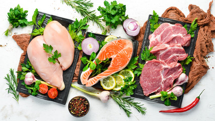 Raw meat set: Veal, pork and fish. Top view. On a white wooden background. Free space for your text.