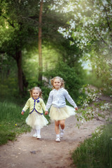 girls sisters walk in the garden, cherry blossoms, blooming, spring, may