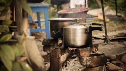 pot on top of burning logs on the ground