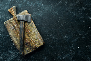 Old ax on a black stone background. Top view. Free space for text.