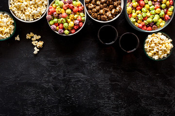 Colored popcorn in box on black background top view copy space