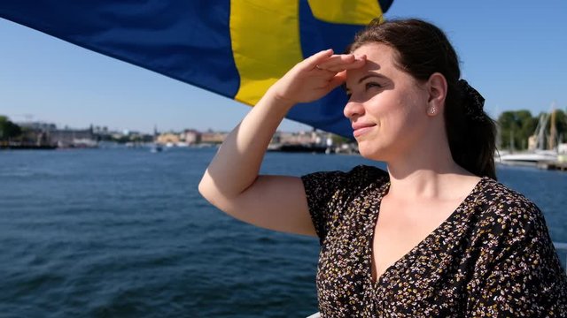 Woman on a ferry in Stockholm against the background of the Swedish flag.