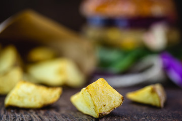 french fries for snacks, hamburger side dish. gourmet potato, sliced ​​in a paper bag, rustic, fried with skin.