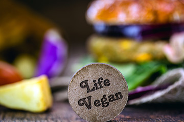small wooden sign with the English phrase: Vegan life. Concept of vegan food, vegetarian lifestyle or change in eating habits.