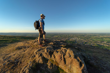 Fototapeta premium A man standing on a mountain summit overlooking British countryside
