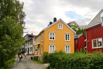 Fototapeta na wymiar A picturesque street with colorful wooden houses in Bakklandet district. Old neighbourhood in Trondheim, with small wooden houses and narrow streets.