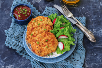 Pan fried chicken mince cutlets with spring onion lettuce radish and tomato sauce  on dark background