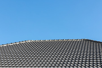 Gray tile roof of construction house with blue sky.