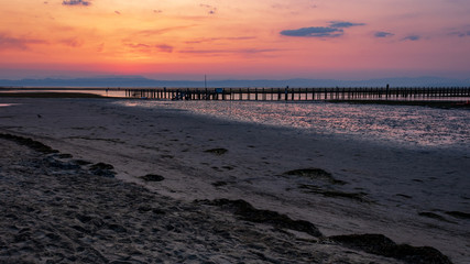 Scenic view of sunrise at the sand beach with footbrige during low tide in Grado, Italy. 