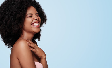 Optimistic black woman laughing near empty space