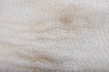 top view macro handmade openwork binding creamy, knitted, woolen scarf with pattern