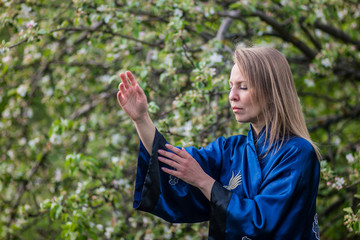 girl martial artist practicing tai Chi in the blooming garden