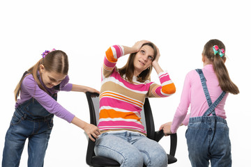 Two daughters are spinning mom in an office chair, mom is spinning