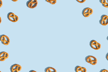Crunchy Brezeln or salted Pretzel on blue background with copy space. Top view, flat lay. Traditional snack for Octoberfest