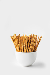 Crispy salty cookies in the shape of sticks close up on a white background