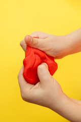 Red plasticine in children's hands