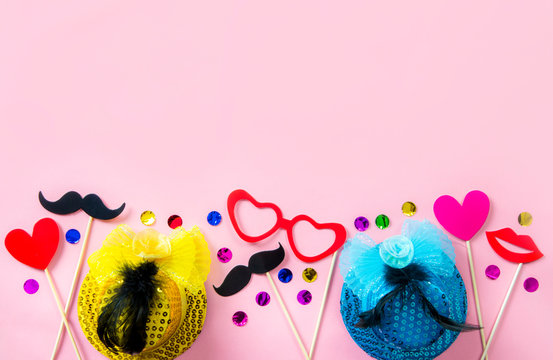 Flat lay view of pink background with fun birthday party decorations props. A lot of room for text.
